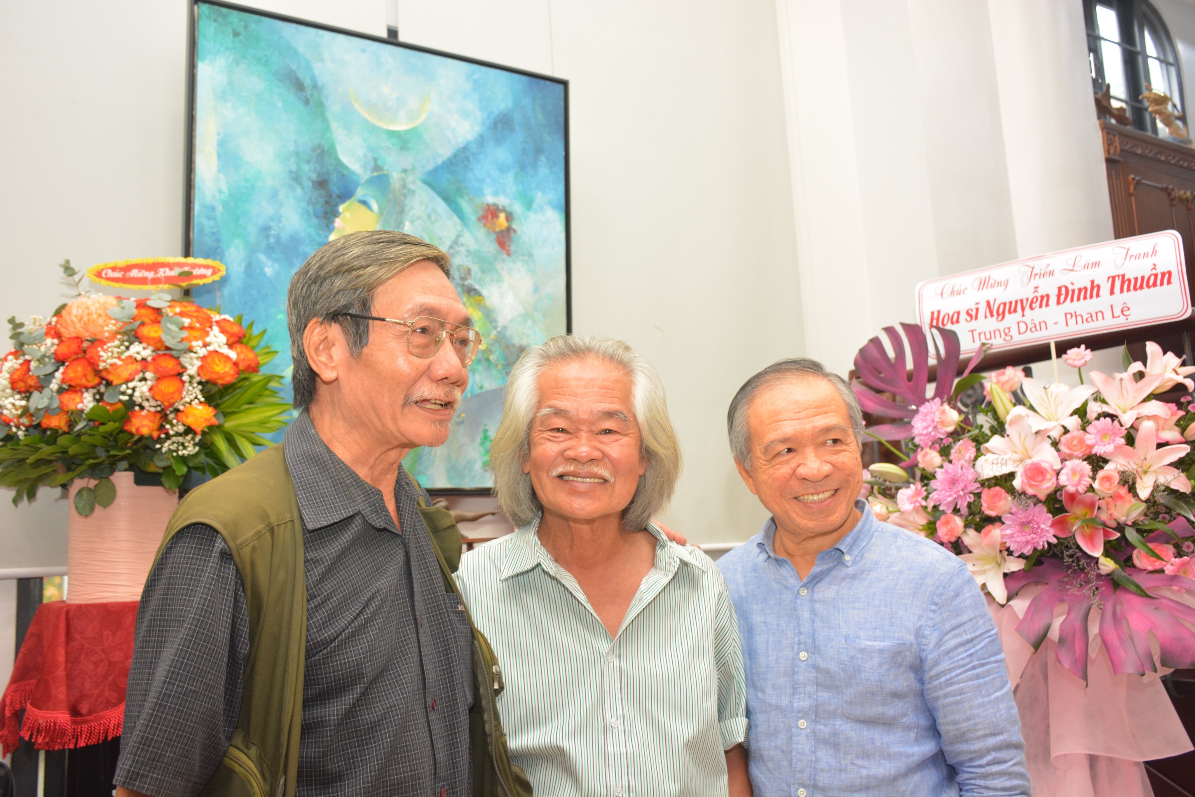 Họa sĩ Nguyễn Đình Thuần (đứng giữa) tại buổi khai mạc triển lãm tranh ở TP. Hồ Chí Minh - Ảnh: Trần Lợi.